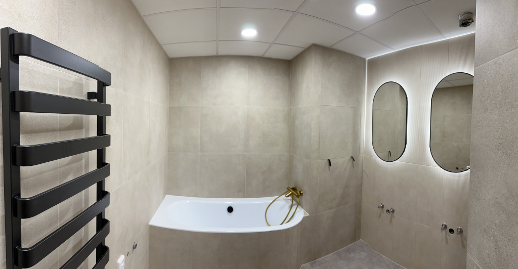 Luxusní koupelna s rohovou vanou a zlatou baterií